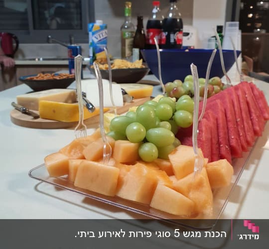 מגש פירות עם מלון, ענבים ואבטיח על שולחן